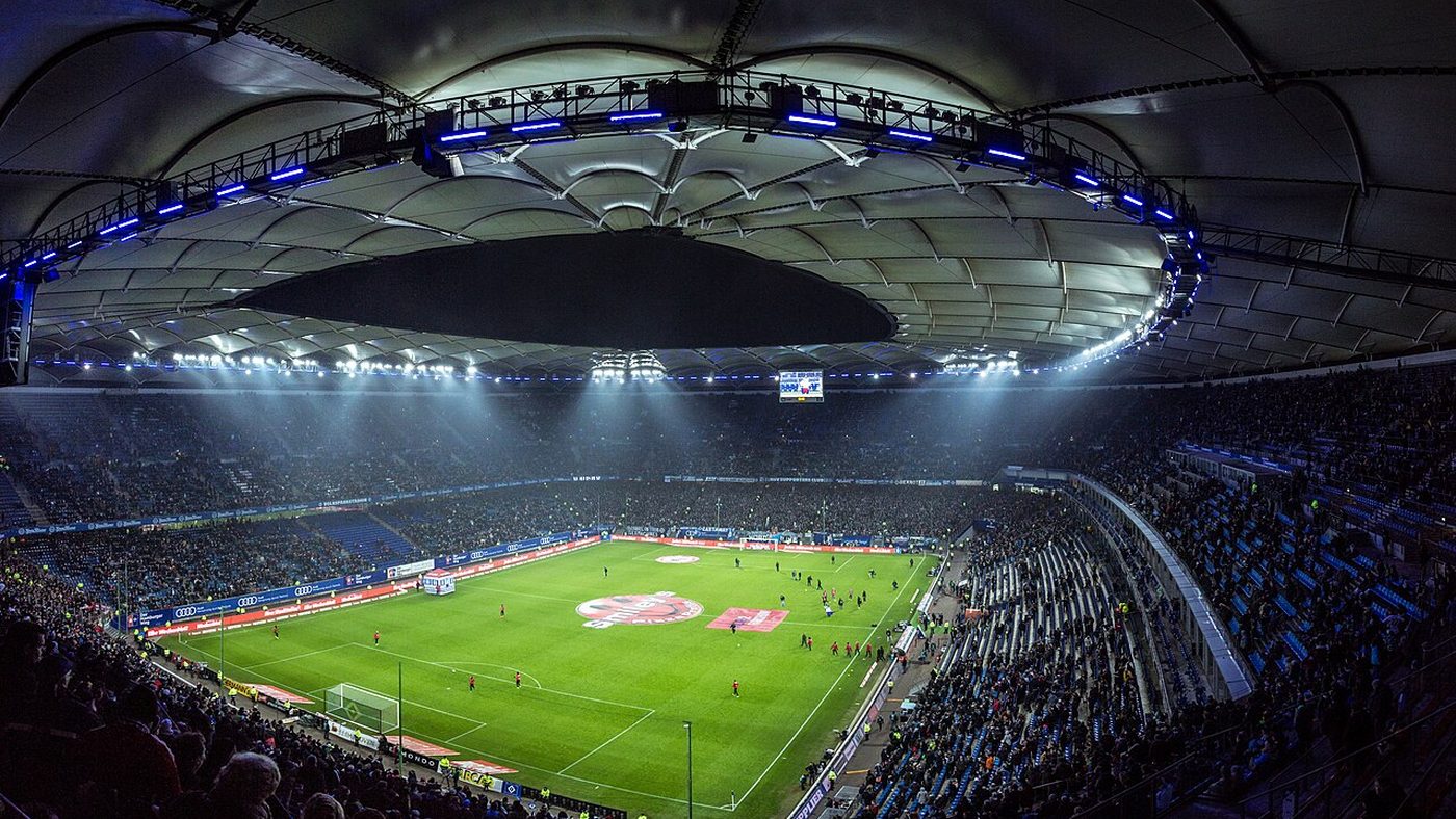 Night football stadium with floodlights and a full stand